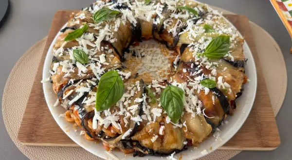 Anelletti al forno alla siciliana con melanzane, un piatto invitante con pasta, melanzane, formaggio grattugiato e basilico fresco.