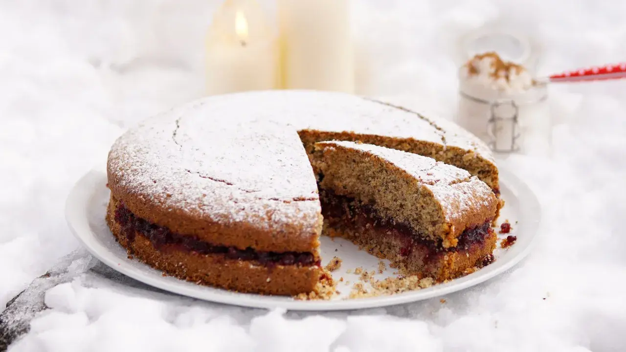 Torta di grano saraceno con marmellata, spolverata di zucchero a velo, su un letto di neve.