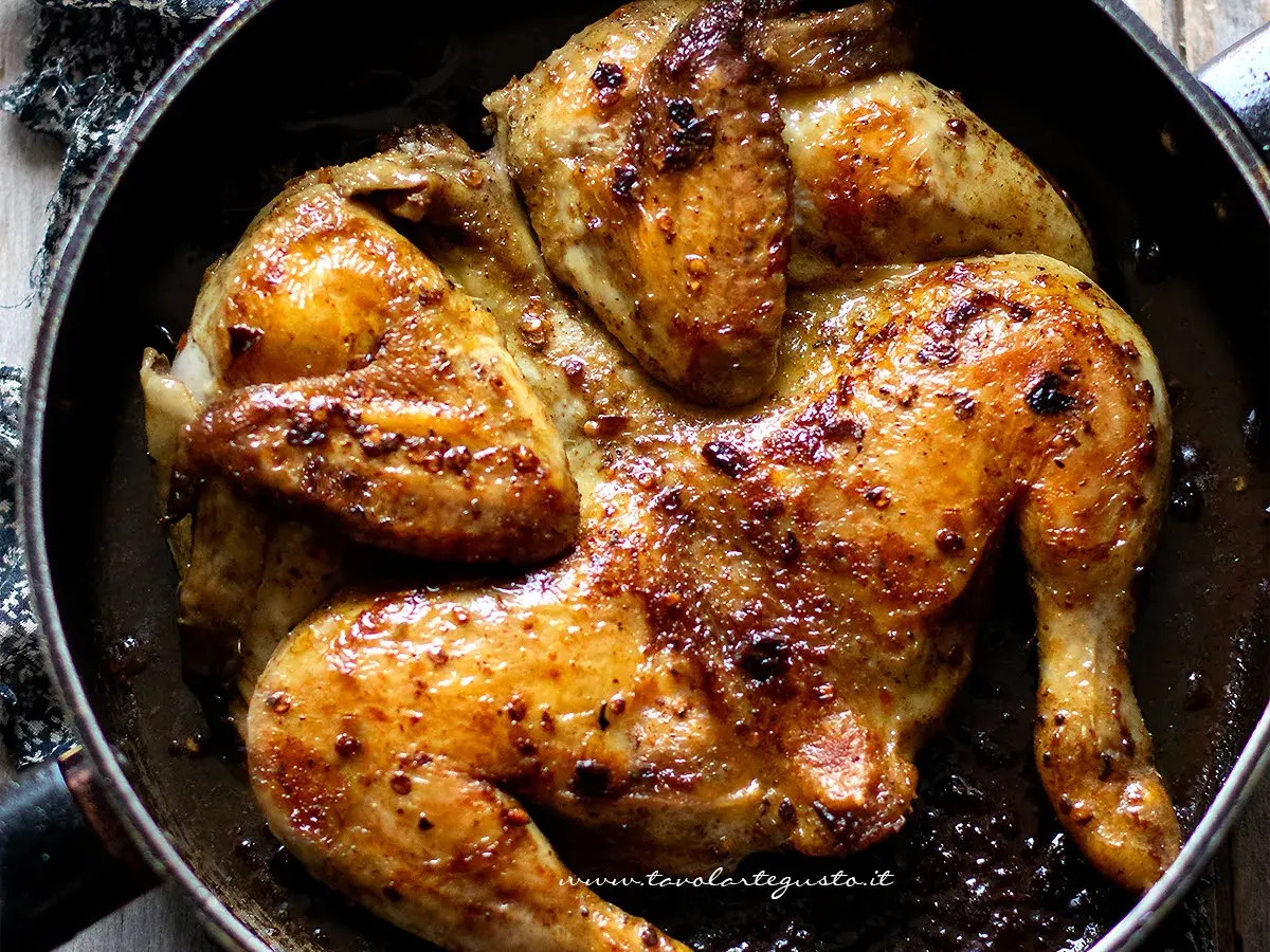 Pollo alla diavola succulento e dorato, cotto in padella con spezie piccanti. Un piatto invitante e saporito.