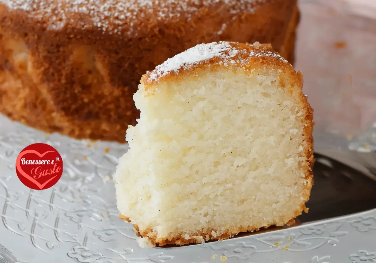 Una fetta di torta senza glutine, soffice e dorata, cosparsa di zucchero a velo. Un piacere per il palato e per il benessere.