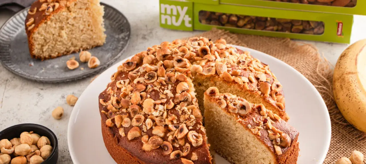 Delizioso dolce con banane e nocciole tostate, una fetta è già servita.