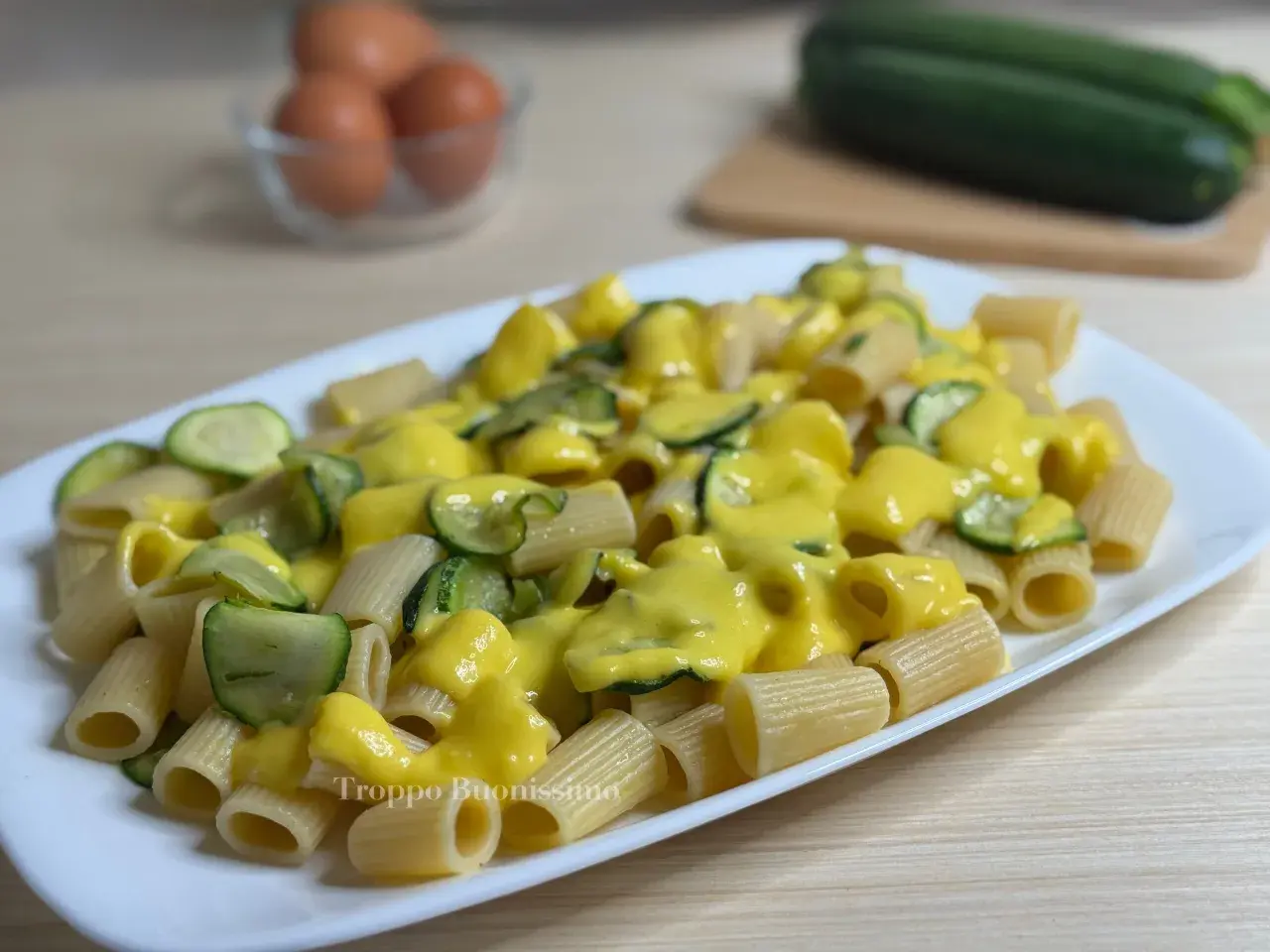 Piatto di rigatoni conditi con una cremosa salsa gialla e zucchine a rondelle. Una deliziosa carbonara di zucchine pronta da gustare.