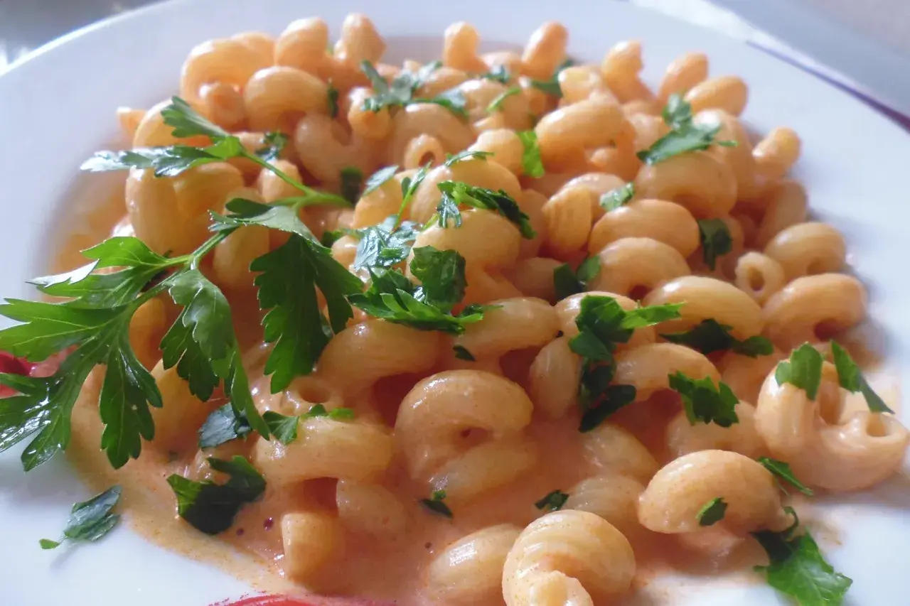 Un piatto invitante di pasta al limone cremosa, guarnita con prezzemolo fresco.