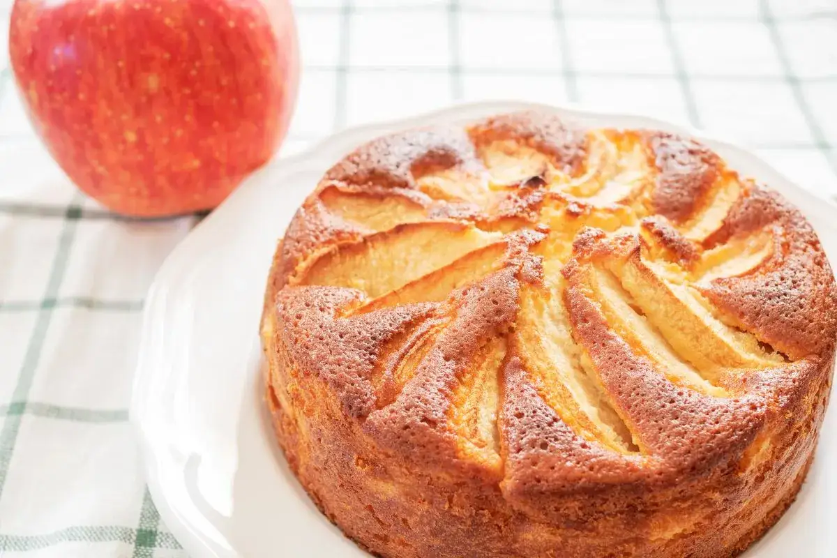 Una deliziosa torta di mele light, dorata e profumata, con mele fresche disposte a raggiera.