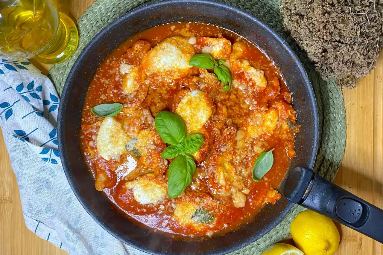 Succulento pollo alla pizzaiola in padella, con mozzarella filante, pomodoro e basilico fresco. Un classico della cucina italiana pronto da gustare.