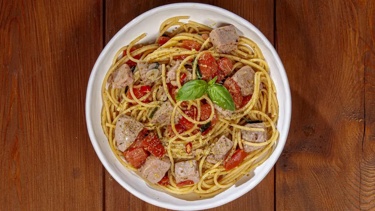 Spaghetti con cubetti di tonno fresco, pomodorini, aglio e basilico, un piatto estivo da gustare.