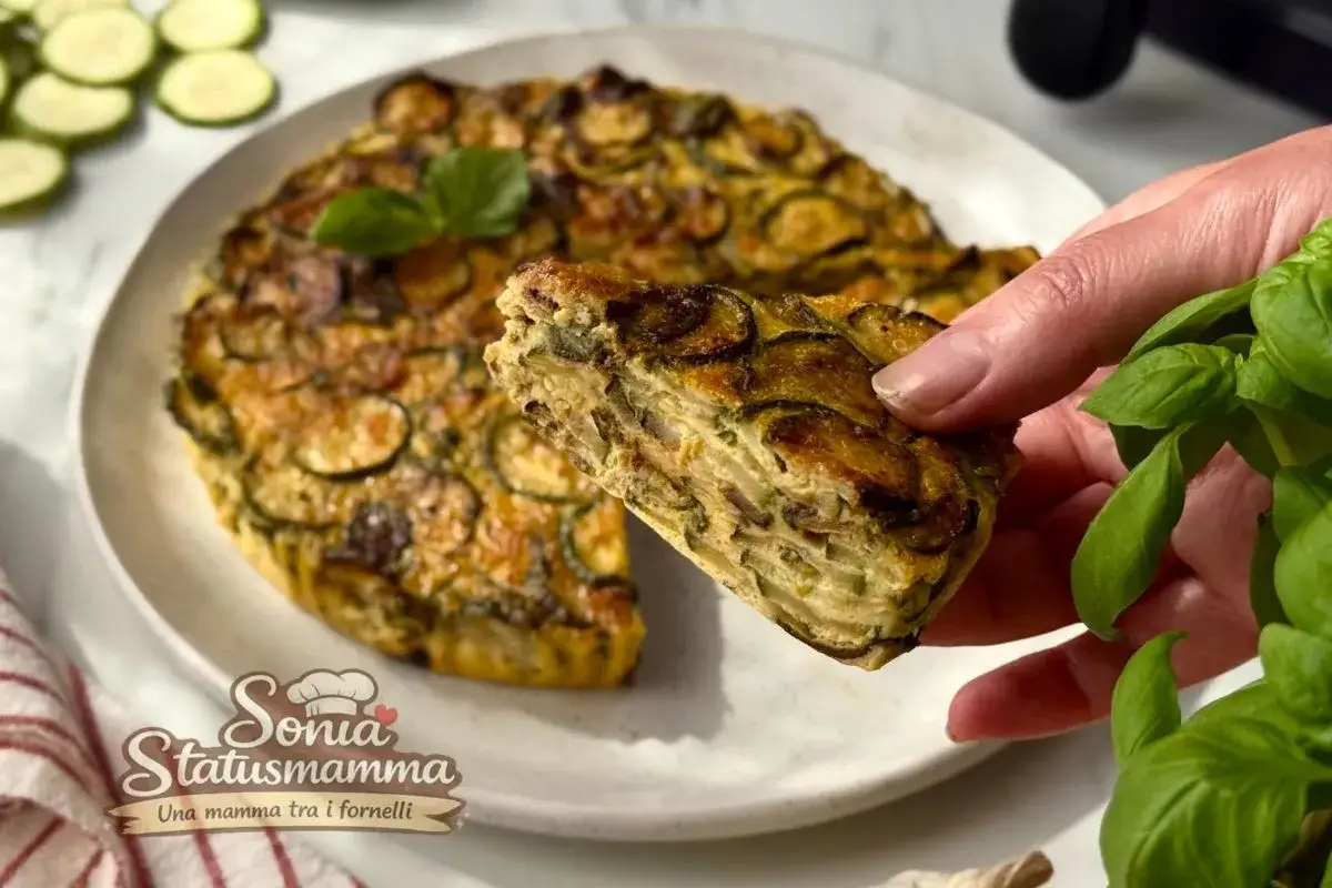 Fetta di frittata in friggitrice ad aria con zucchine, dorata e soffice, pronta per essere gustata.