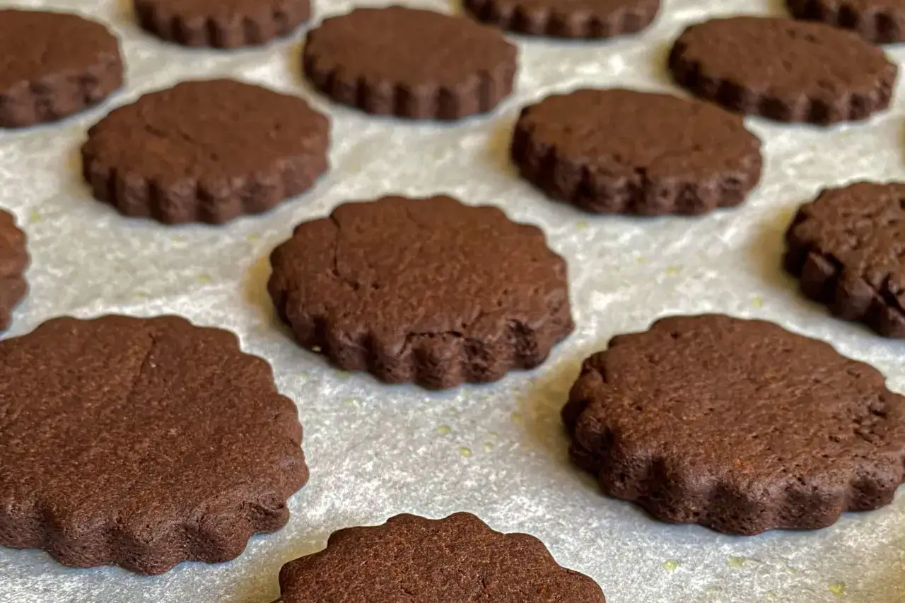 Deliziosi biscotti senza burro al cacao, con bordo ondulato, pronti per essere gustati.