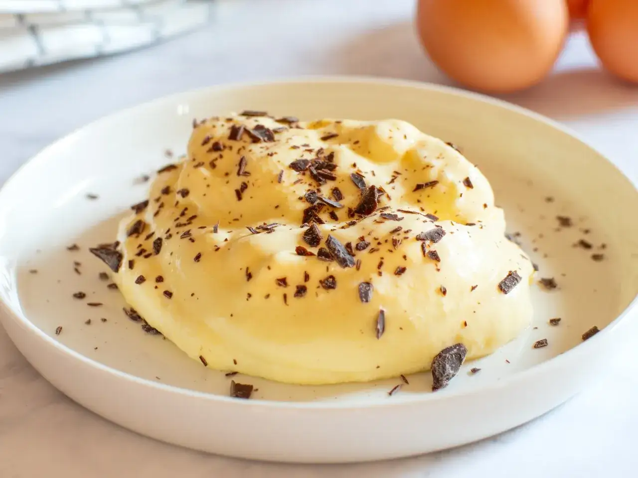 Una soffice crema al mascarpone, guarnita con scaglie di cioccolato fondente, pronta per essere gustata.