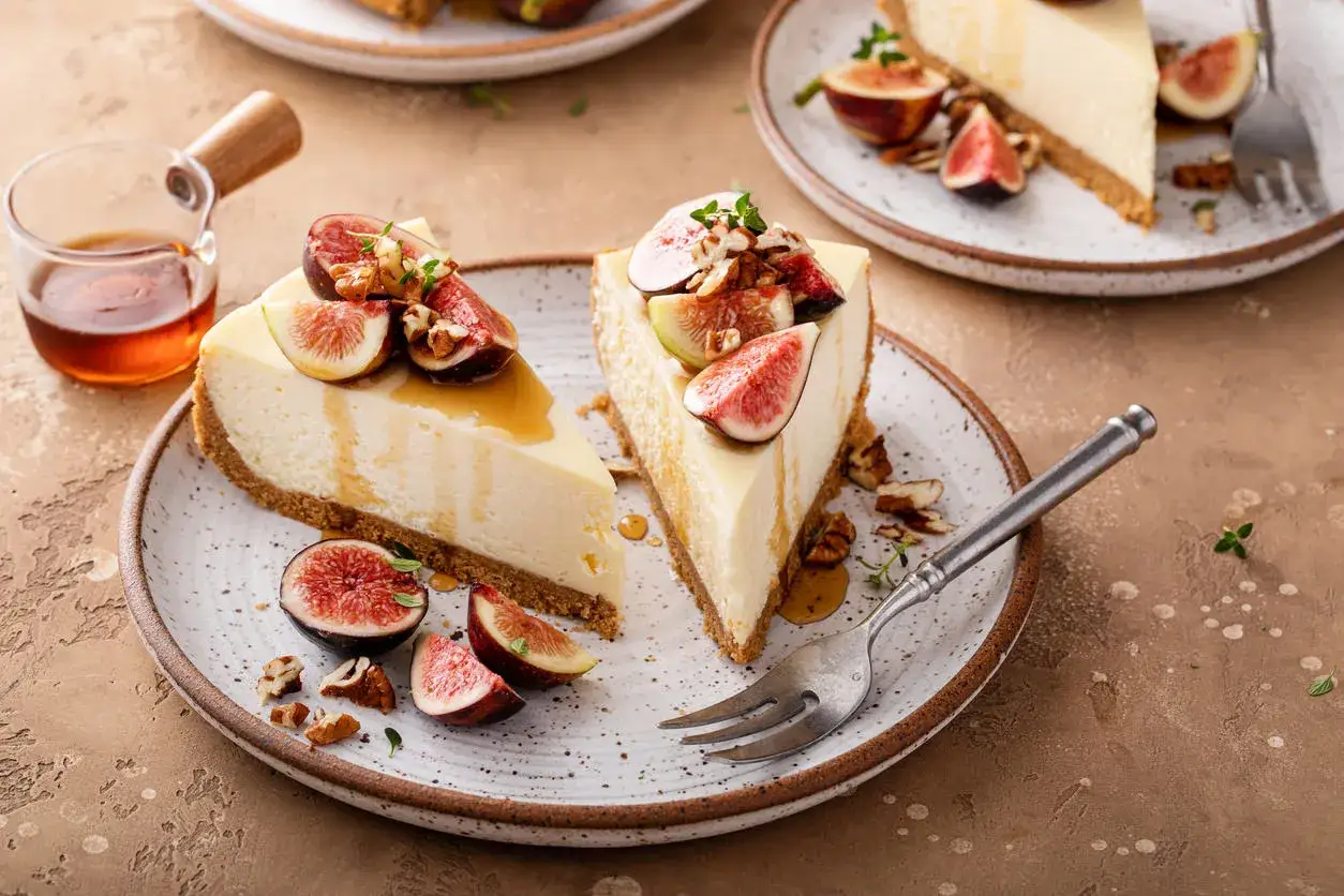 Delizioso cheesecake ai fichi, guarnito con fichi freschi, noci e miele dorato.