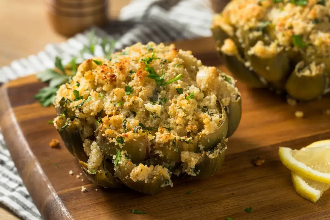 Deliziosi carciofi ripieni e dorati, cotti alla perfezione nella friggitrice ad aria, guarniti con prezzemolo fresco e spicchi di limone.
