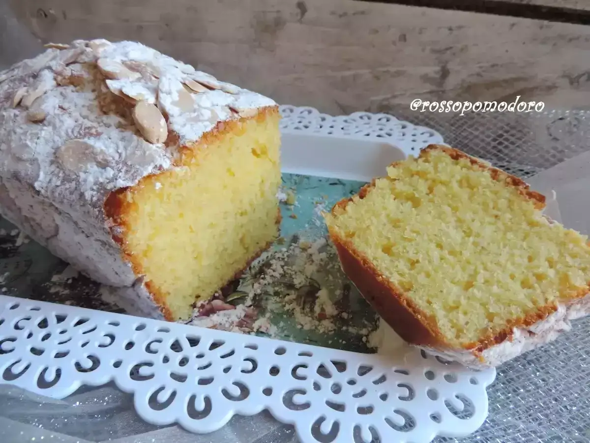 Delizioso plumcake yogurt greco, soffice e cosparso di mandorle a lamelle e zucchero a velo. Perfetto per la colazione.