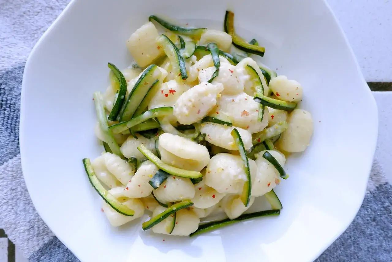 Gnocchi di zucchine cremosi, conditi con zucchine a julienne e un pizzico di peperoncino. Un piatto leggero e saporito.