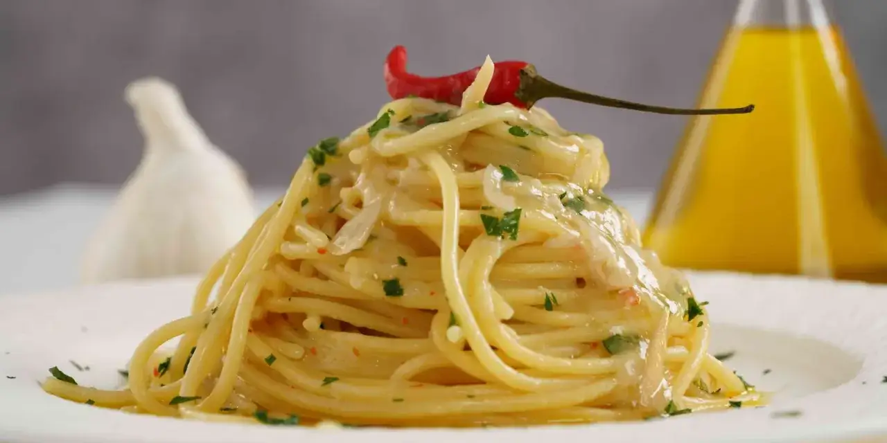 Spaghetti aglio, olio e peperoncino with a creamy sauce, garnished with chili and parsley.