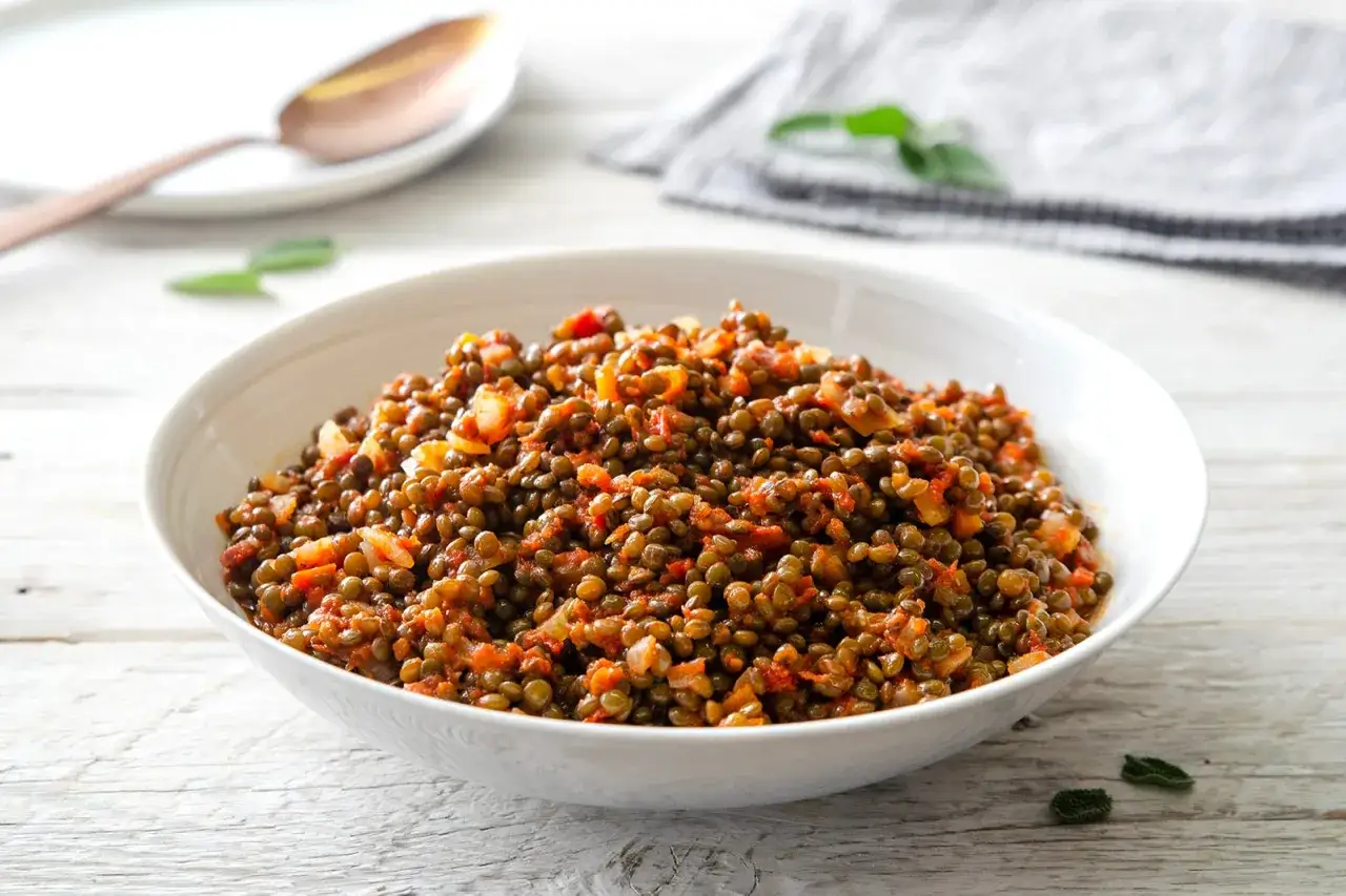 Un piatto invitante di lenticchie stufate con pomodoro e cipolla, perfetto per le tue ricette con lenticchie.