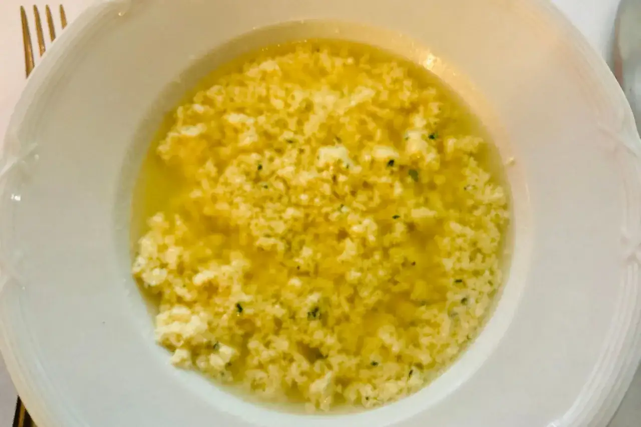 Stracciatella alla romana in una ciotola bianca, un piatto caldo e confortante con uova, parmigiano e prezzemolo.