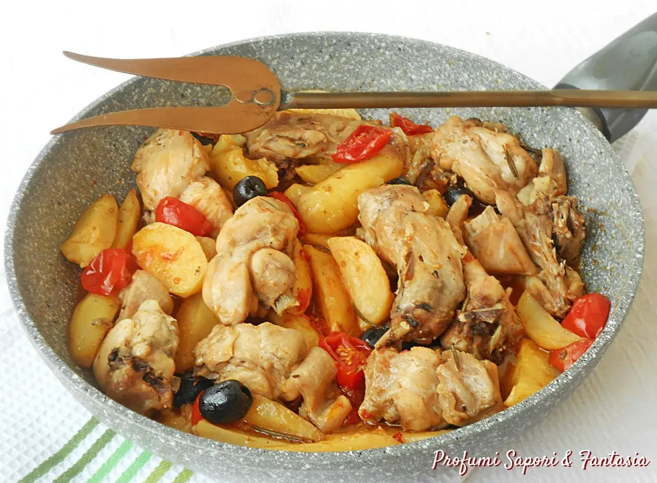 Un saporito coniglio in padella con patate, pomodorini e olive nere. Un piatto rustico e invitante, pronto per essere gustato.
