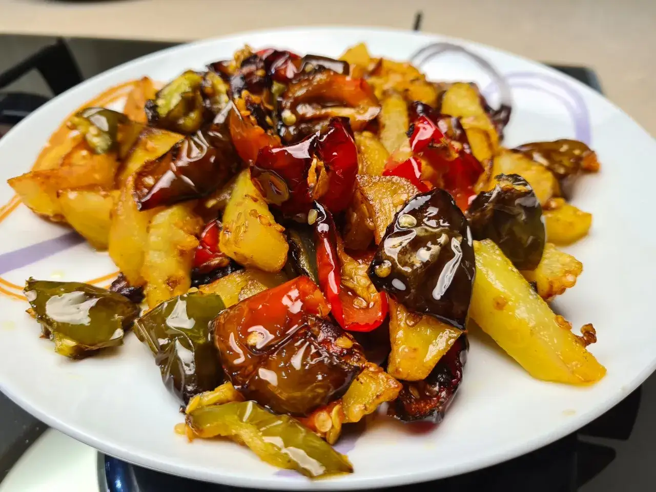 Un piatto invitante di pipi e patate saltate, con peperoni verdi e rossi croccanti e patate dorate, condite con olio e spezie.
