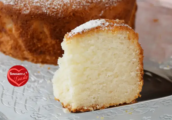 Una fetta di torta senza glutine, soffice e dorata, cosparsa di zucchero a velo. Un piacere per il palato e per il benessere.