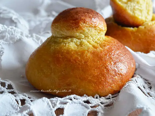 Brioche col tuppo dorate e soffici, pronte per essere gustate.