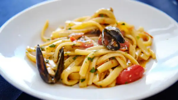 Un piatto invitante di scialatielli ai frutti di mare, con cozze, pomodorini e prezzemolo fresco.