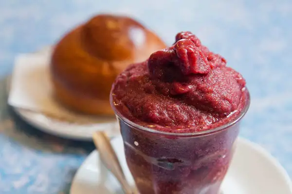 Brioche soffice con una generosa porzione di gelato ai frutti di bosco, un'accoppiata perfetta per una pausa golosa.