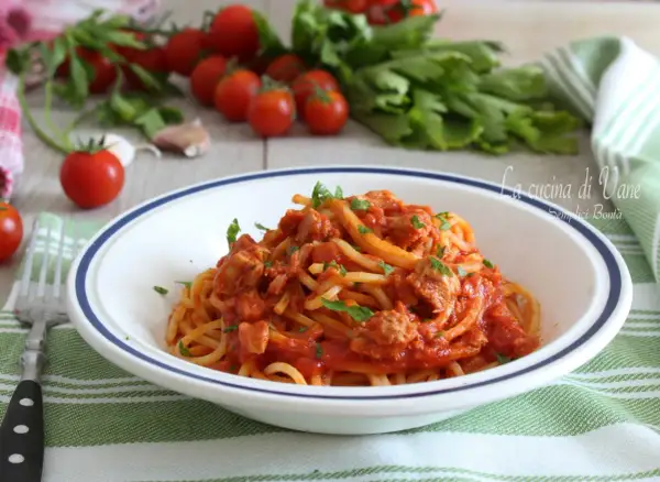 Un piatto di spaghetti al tonno, un classico della cucina di Vane, con pomodorini freschi e prezzemolo.