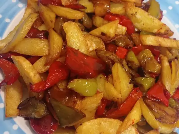 Un gustoso contorno di patate fritte e peperoni colorati, un classico piatto di pipi e patate.