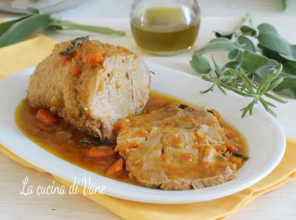 Arrosto di vitello morbido con sughetto benedetta, profumato con erbe aromatiche e carote. Un piatto succulento che invita a gustare ogni fetta.