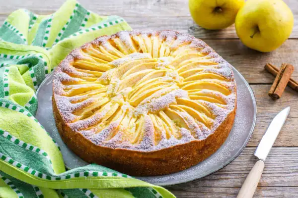 Una deliziosa torta di mele light, decorata con fettine di mela e zucchero a velo, pronta per essere gustata.